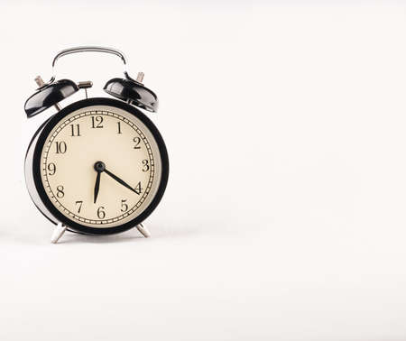 Black alarm clock on white textile backgroundの写真素材