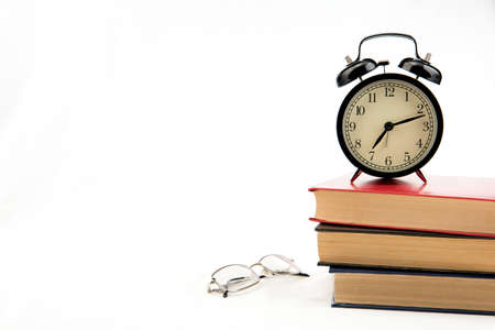 Tree books with alarm clock on whiteの写真素材