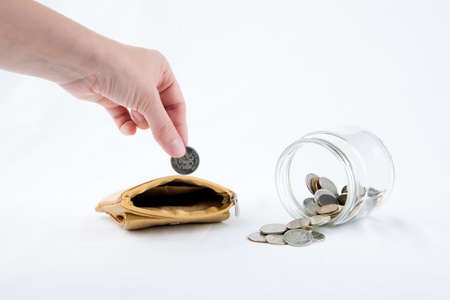 Women hand puts coin into the walletの写真素材