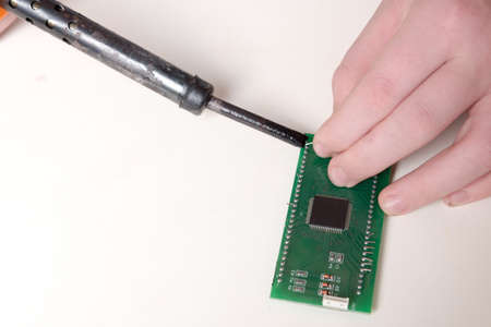 Microchip repair with soldering iron by human handsの写真素材