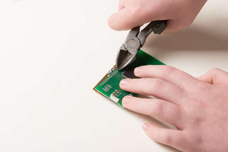 Microchip repair with pliers by human handsの写真素材