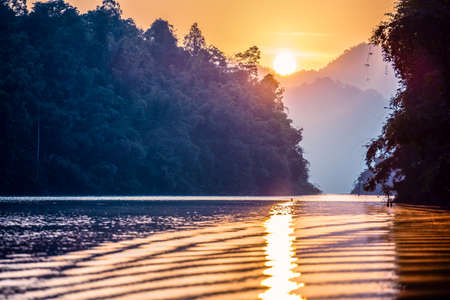 Sunset on forest lake backgroundの写真素材