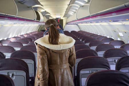 Young woman in airplane traveling to a tourist attraction
