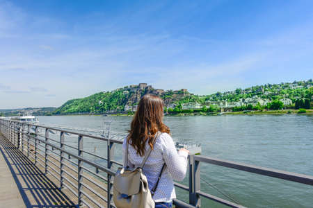 Rear view of woman standing by railing protection on promenade river, lakeの写真素材