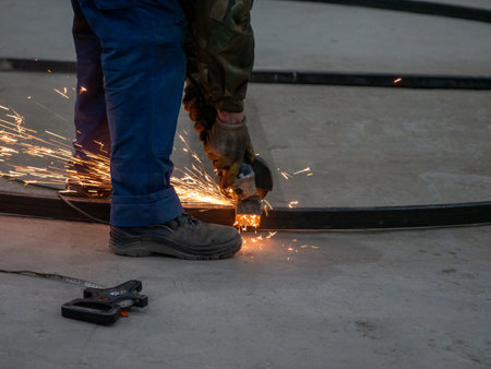 worker cutting metal with angle grinder at construction site, closeupの写真素材