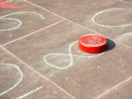Red hockey puck and chalk on the playground, closeup of photoの写真素材