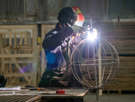 Welder working at the construction site. Metalworking. Sparks from welding.の写真素材