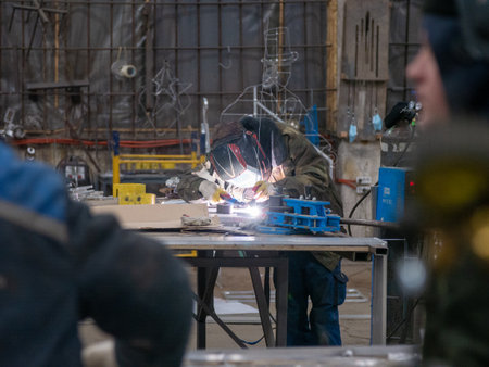 Welding work in the workshop. A man welds metal with a arc welding machine.の写真素材