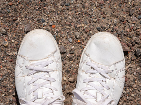 White sneakers on the ground. White sneakers on the background of the road.の写真素材