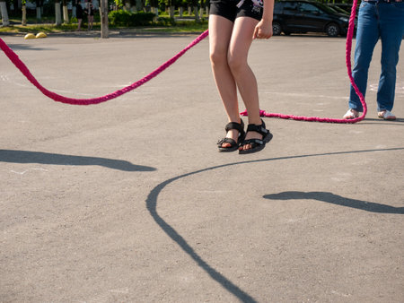 Happy kids play outdoor. Children skipping rope on sunny dayの写真素材