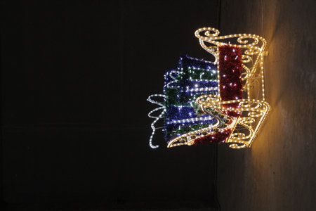 Christmas presents in sleigh with lights on black backgroundの写真素材