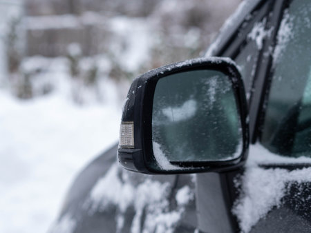 Car fragment with side mirror in snow. Blurred background.の写真素材