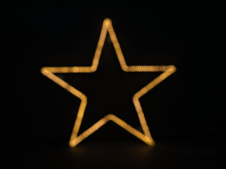 Christmas star shape bokeh light on black background. Christmas and New Year concept.の写真素材