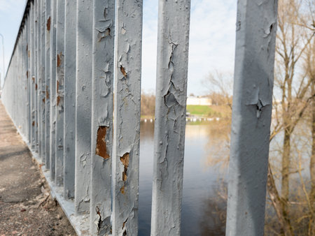 Rusty iron fence on the bank of the river in the springの写真素材