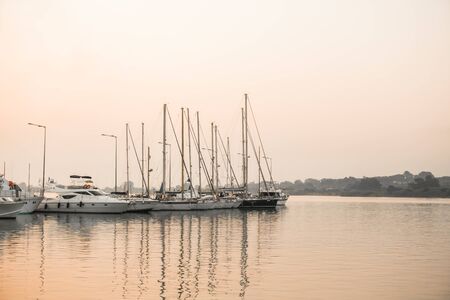 Small amateur fishing boats at pier with calm waterの写真素材