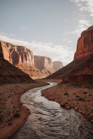 Canyon with river on bottom, national park. Red sandstone mountains, horizon with sand rocks and sky, nature landscape background, created with the help of artificial intelligence.の素材