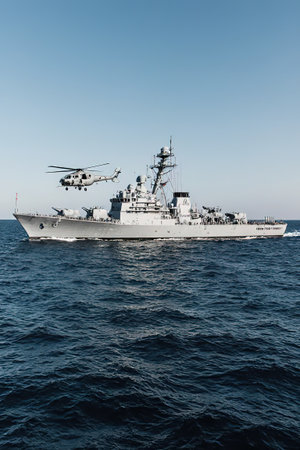 A warship sails on the sea.Battleship war ship corvette with helicopter on deck performing military exercises in the Baltic Sea. Warship boat carrying helicopter sailing in beautiful blue sea. Military warship.View of a warship, battleship, warhead, warship, stable and equipped with weapons systems, including weapons on amphibious transports. auxiliary warship. Naval transport.created with the help of artificial intelligence.の素材