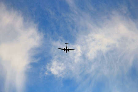 Light aircraft landing on a cloudy sky