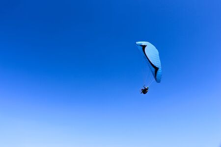 paraglider flying in blue sky on valleys landscape in Indonesia