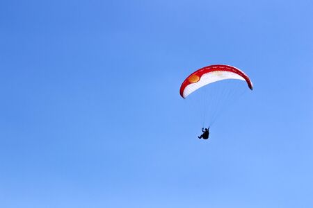 paraglider flying in blue sky on valleys landscape in Indonesia