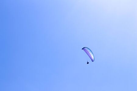 paraglider flying in blue sky on valleys landscape in Indonesia