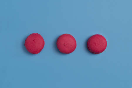 Crimson macarons on a blue backgroundの写真素材