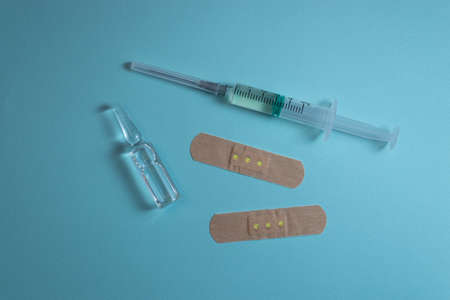 Ampoule, syringe and patches lying on blue backgroundの写真素材