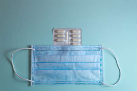 White, red and yellow pills on blue background with a hard shadowの写真素材