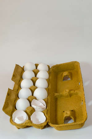 Box with twelve white eggs, 3 broken eggs on an isolated white background. food ingredient, healthy...