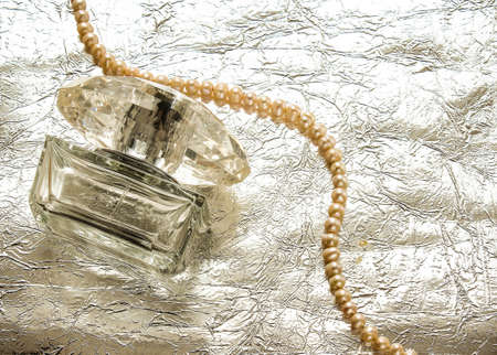 Transparent bottle of female perfume on a silver backgroundの写真素材