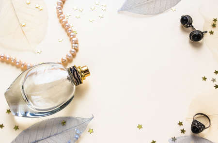 Transparent female perfume on a light background with decorative leavesの写真素材