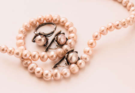 Beautiful pearl jewelry in a delicate pink color, earrings and beadsの写真素材