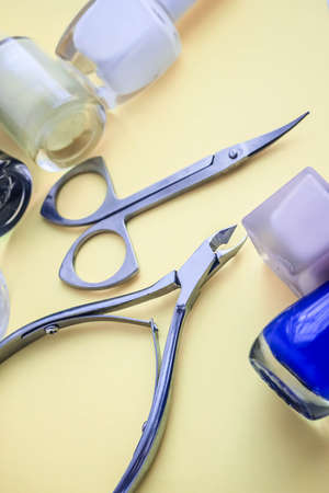 Set for nail care, manicure tools scissors, nippers, varnish on a yellow backgroundの写真素材