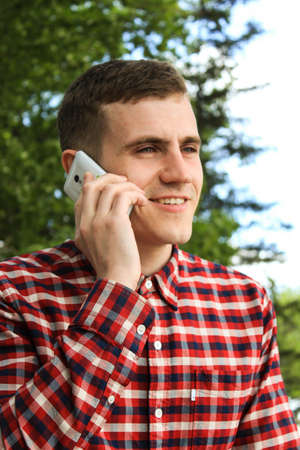 Guy in checkered shirt calling on the phoneの写真素材