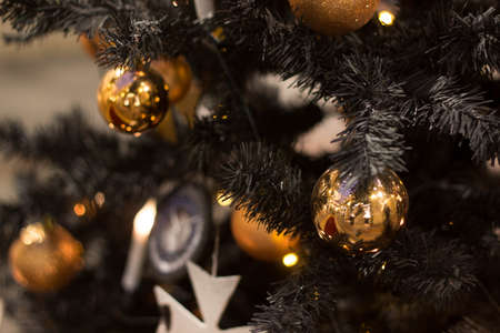 golden Christmas balls hanging on the tree, beautiful decoration for the new yearの写真素材