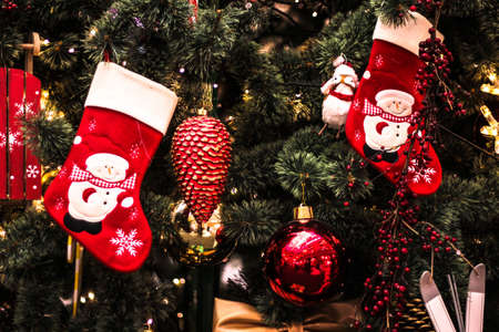 New Year's toys hang on the Christmas tree, festive decoration on the tree of Santa Claus sock,...