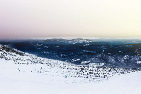 skiing down the slope in the french alps with the valley and the mountains ahead and low cloudsの写真素材