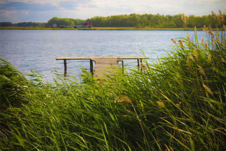 a large lake, a summer landscape, a sunny day, a jetty near the waterの写真素材