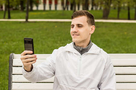 Picture of young man make a selfie by phone. Looking at phone.の写真素材
