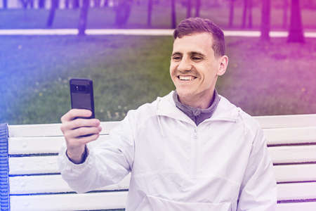 Picture of young man make a selfie by phone. Looking at phone.の写真素材