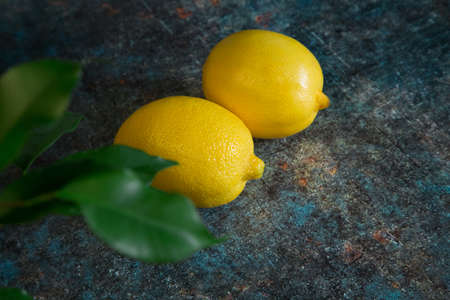 Two lemons on a blue background. Cold medicine. Fruit for lemonade.の写真素材