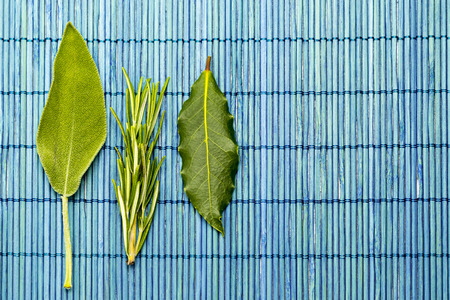 Wooden flat with sage leaves laurel rosemaryの写真素材