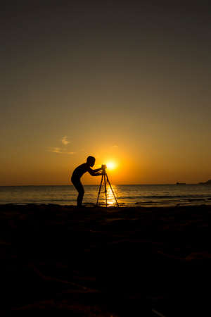 Silhouette children photographer at sunsetの写真素材