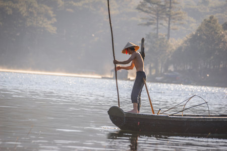 Fisherman in a boat on the lake in the morning.の写真素材