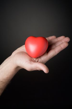 Red symbolical heart lies on a man's handの写真素材