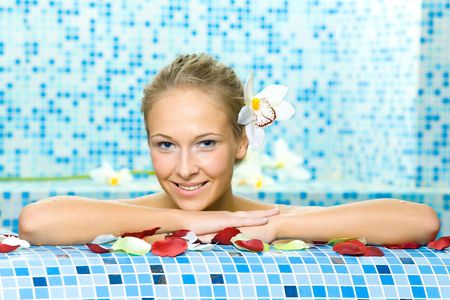 The young beautiful girl floating in poolの写真素材