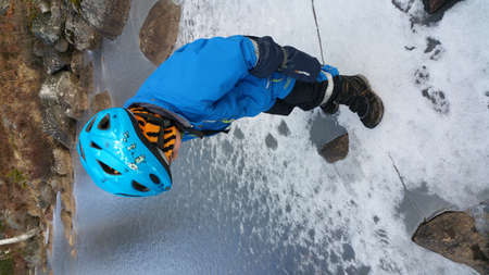 A boy enjoys playing snow on an ice lakeの写真素材