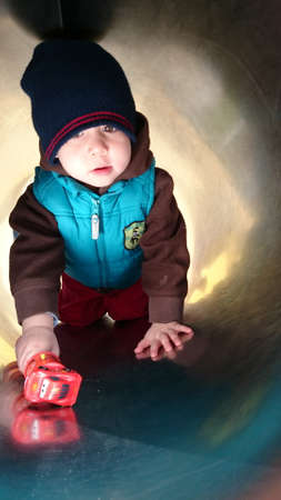 A boy playing in the playground tunnel