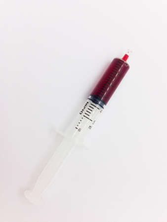 Medication concept, syringe with red medical syrup for children, isolated on white background.の写真素材