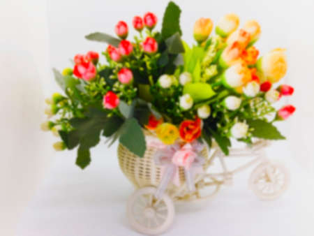 Bright and colorful plastic flower bouquet are in the white bicycle vase, isolated on white background with copy space. Valentine and love concept.の写真素材